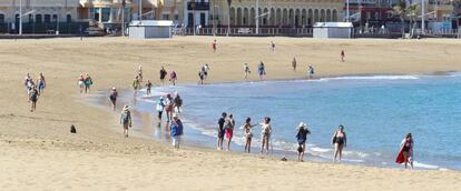 Varias personas mayores pasean por la orilla de la playa de Las Canteras este sábado, día que ha amanecido con cielos despejados y temperaturas veraniegas. 