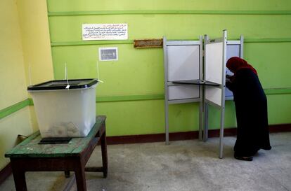 Una mujer prepara su papeleta en una cabina antes de votar en un centro electoral de El Cairo, el 26 de marzo.