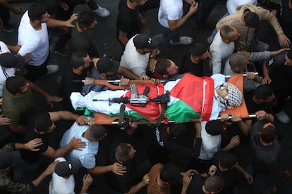  Una multitud acompañaba el cadáver de un miliciano palestino, supuestamente abatido en un enfrentamiento con las tropas israelíes, durante su funeral en la ciudad cisjordana de Yenín, el miércoles.
