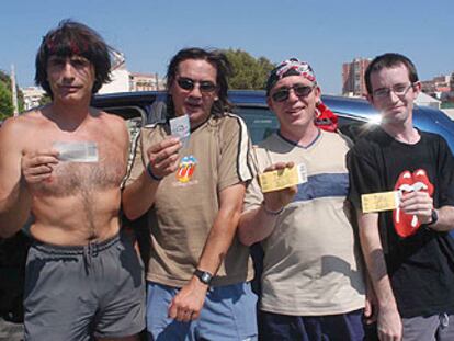 Seguidores de los Stones, ayer en Benidorm, con la entrada del concierto suspendido en la mano.