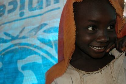 2005, Darfur, Sudán. Los proyectos del PMA casi siempre se desarrollan conjuntamente con ONG locales o internacionales, diversas dependencias gubernamentales, u otras agencias de Naciones Unidas. Como se aprecia la imagen, la bonita sonrisa de esta niña desplazada por el conflicto en Darfur está enmarcada por el emblema de Unicef, nuestro compañero de trabajo en proyectos de alimentación escolar.