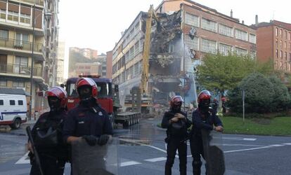 Agentes de la Ertzaintza vigilan el derribo del inmueble donde se encontraba Kukutza, al día siguiente de su desalojo.