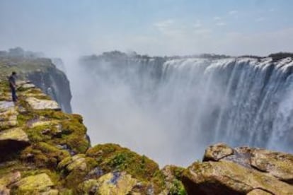 Un turista contemplando las cataratas Victoria, desde el lado de Zimbabue.