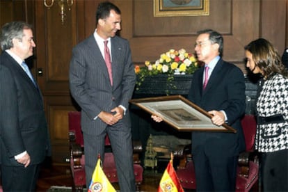 El príncipe de Asturias, Felipe de Borbón, entrega un regalo al presidente de Colombia, Alvaro Uribe (2 der), en presencia del embajador español en Colombia, Carlos Gómez Mújica (izq), y la recién nombrada canciller colombiana, María Consuelo Araujo (der), durante la reunión que mantuvieron hoy, lunes 7 de agosto, en Bogotá. Don Felipe se encuentra de visita en Colombia para asistir a la toma de posesión, por segundo período consecutivo, del presidente colombiano