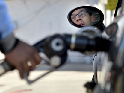 Un hombre reposta combustible en una gasolinera. 