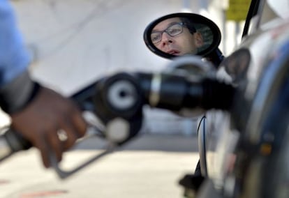 Un hombre reposta combustible en una gasolinera. 