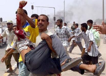 Un manifestante transporta en brazos a un herido, esta mañana en Basora.