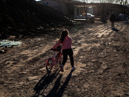 Una niña arrastra una bicicleta en el poblado chabolista de la Cañada Real en Madrid, el pasado 4 de enero.