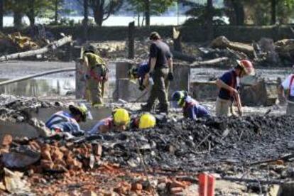 Fotografía del 8 de julio de 2013 cedida por la Policía provincial de Québec el 9 de julio de 2013 que muestra a varios trabajadores en los escombros donde un tren cargado de petroleo explotó el 6 de julio, en la localidad de Lac-Mégantic, Québec, Canadá. EFE/Archivo