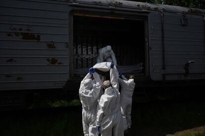 Expertos forenses ucranios a punto de examinar el miércoles el cuerpo de un soldado ruso exhumado en la aldea de Zavalivka, al oeste de Kiev, en un vagón refrigerado donde se almacenan los cadáveres de los militares rusos. Hasta la fecha, se han recogido y almacenado los cuerpos sin vida de más de 230 rusos, la gran mayoría a las afueras de la capital ucrania. 
