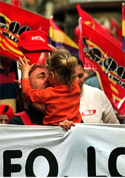 Una niña coloca la gorra a su padre durante la manifestación de ayer en Valencia.