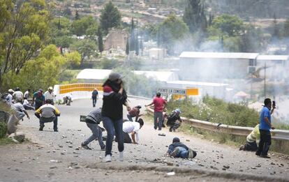 Maestros contrarios a la reforma educativa se resguardan durante el enfrentamiento con policías, en el poblado de Hitzo, Oaxaca.