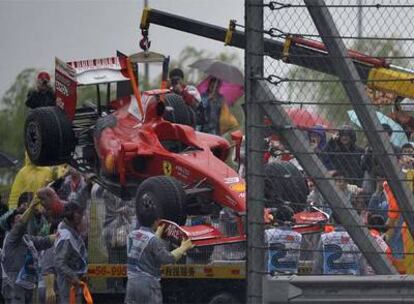 Mecánicos de Ferrari retiran el coche de Massa del Circuito de Shanghai.