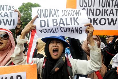 A supporter of Indonesian Presidential candidate Anis Baswedan and running mate Muhaimin Iskandar shouts slogans and holds a poster reading 'President Joko Widodo's syndicate is behind the fraudulent election' during a protest in front of the Election Commission Office in Jakarta, Indonesia, 16 February 2024.