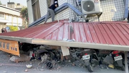 Imagen captada de un video publicado por TVBS, donde se muestra a un hombre que mira en el interior de un edificio parcialmente derrumbado en Hualien, este miércoles.