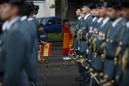 La parada militar comenzó tras el homenaje a los que dieron su vida por España. En la imagen, unos niños contemplan a los militares que han participado en el desfile por el centro de Madrid.