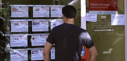 Un hombre mira el escaparate de una inmobiliaria en Madrid.