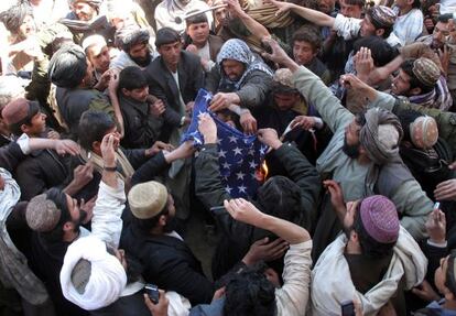 Afganos queman una bandera de EE UU en Helmand.