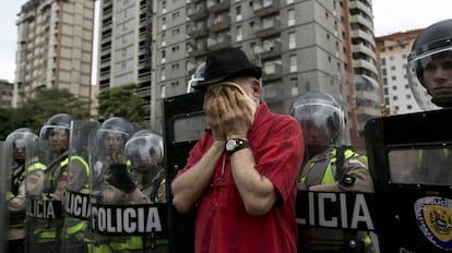 Un opositor se frota la cara ante la Polic&iacute;a. 