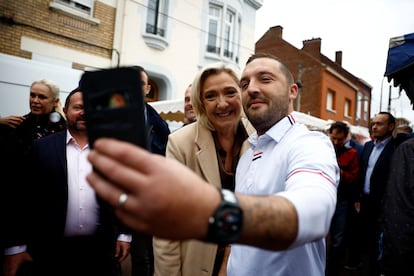 Marine Le Pen, líder del RN, posa para una foto con un vecino de la localidad de  Henin-Beaumont, en el norte de Francia, el 14 de junio de 2024.