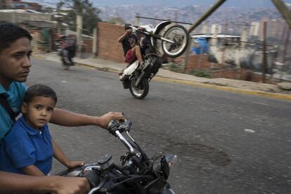 Un hombre levanta la rueda de su motocicleta mientras otros motociclistas se abren paso a través de Caracas, Venezuela.