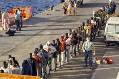 Miembros de la Guardia Civil atienden a los 114 inmigrantes indocumentados que arribaron ayer por la tarde a La Gomera.