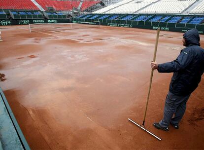 Un operario limpia la pista de Benidorm anegada por la lluvia.