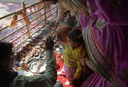 Un sacerdote hindú aplica una marca religiosa en la frente de unos niños durante el festival anual del templo Kheer Bhawani en Cachemira.