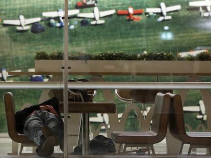 Uno de los viajeros fantasma que dice llamarse David descansa sobre una silla en el aeropuerto.