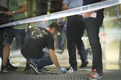 Agentes de los Mossos d'Esquadra buscan pruebas de lo sucedido en la entrada del hotel Silken tras el tiroteo.