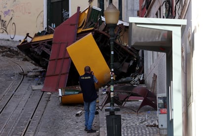 Un agente de policía fotografía los restos del funicular de la Gloria tras el accidente, este jueves en Lisboa.