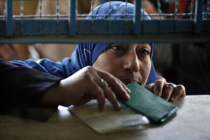 Una mujer palestina presenta su identificación para recibir su ración de víveres en el centro de distribución de alimentos de las Naciones Unidas en Gaza.