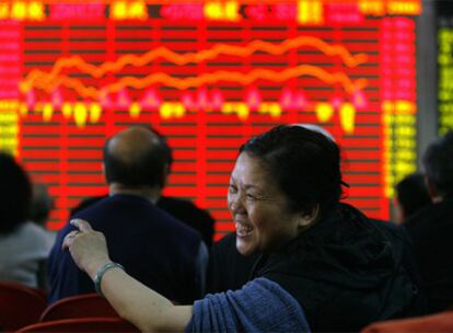 Una mujer sonríe en la sala de una sociedad de Bolsa en la localidad china de Wuhan.