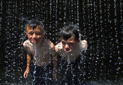 Dos niños juegan con el agua de una fuente en Nottingham (Reino Unido). Los aviones tomarán datos meteorológicos de viento, humedad y temperatura en sus despegues y aterrizajes de 37 aeropuertos europeos, según se ha acordado en una reciente reunión en la que han participado los servicios meteorológicos de seis países, entre los que figura la Agencia Estatal de Meteorología (AEMET) española.