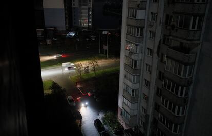 Varios vehículos circulaban por una zona residencial durante uno de los apagones en Kiev (Ucrania), el martes. 
