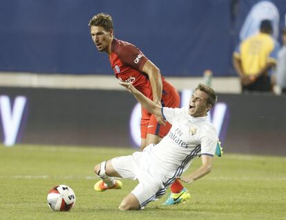 El centrocampista Benjamin Stambouli del París Saint-Germain tira al suelo al jugador del Real Madrid Aleix Febas durante el partido que disputaron en la pretemporada.