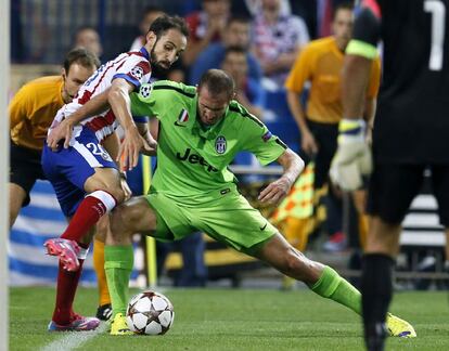 El defensa del Atlético de Madrid Juanfran lucha el balón con el defensa Leonardo Bonucci, de la Juventus.