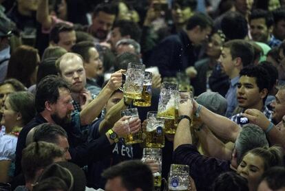 Un grupo de personas brinda con sus jarras de cerveza durante la celebración del Oktoberfest en Múnich (Alemania).