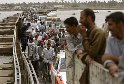 Centenares de iraquíes cruzan por un puente construido con pontones en Basora.