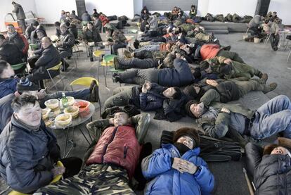 Hacia el mediodía, tras el almuerzo que consiste en una sopa de fideos, los trabajadores descansan en el gran recinto que servirá para actuaciones culturales y musicales.