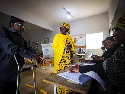 Two voters cast ballots in the presidential elections in Senegal, at a polling station in the capital of Dakar, on March 24, 2024.