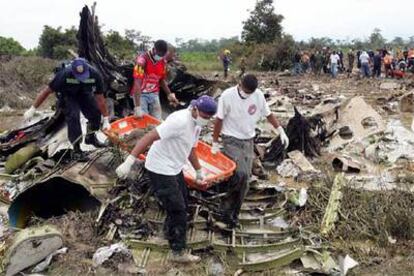 Miembros del equipo de rescate trasladan los restos de una de las víctimas del accidente.