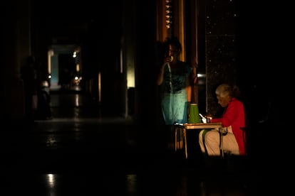 Un grupo de vecinas conversan en la calle en la calzada 10 de octubre, durante el apagón la noche del viernes 14 de marzo de 2025. 