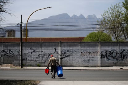 Un hombre carga una cubeta y un bote de basura para almacenar agua y transportarla, en la ciudad norteña de Monterrey. 