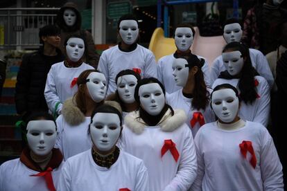 Voluntarios con máscaras blancas durante la celebración del Día Mundial contra el SIDA celebrado en Chongqing (China).