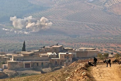Rebeldes sirios apoyados por Turquía observan la nube de humo dejada por un disparo de artillería en un monte junto a la aldea de Al Amud, al norte de Azaz (Siria).