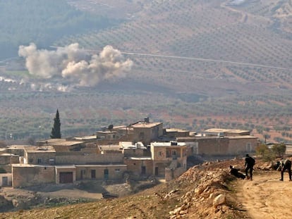 Rebeldes sirios apoyados por Turqu&iacute;a observan la nube de humo dejada por un disparo de artiller&iacute;a en un monte junto a la aldea de Al Amud, al norte de Azaz (Siria).