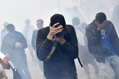 Manifestantes reaccionan al gas lacrimógeno que ha lanzado la policia en la manifestación contra la reforma laboral, en Nantes. 