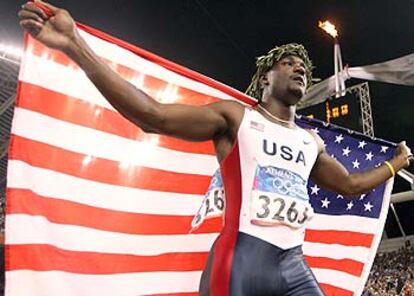 Justin Gatlin celebra, con la enseña de Estados Unidos, su triunfo en los 100 metros.