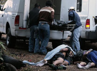 Los forenses de la policía mexicana cargan en camiones los cuerpos de seis hombres tiroteados hoy en Cuernavaca, en el norte de México.